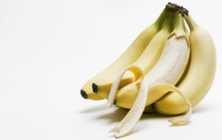 One peeled banana in bunch