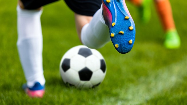 Soccer Kick. Footballer Kicking Ball on Grass Pitch. Football Soccer Player Hits a Ball. Soccer Boots Close Up