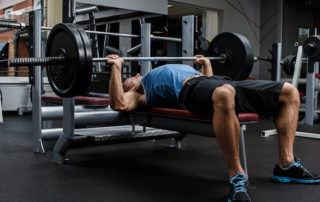 man arching his back while bench pressing