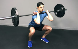athletic male performing a front squat during workout