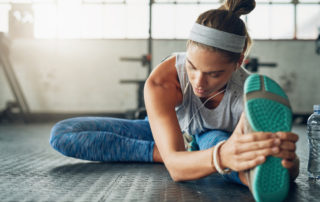 Shot of a young attractive woman stretching in a gym
