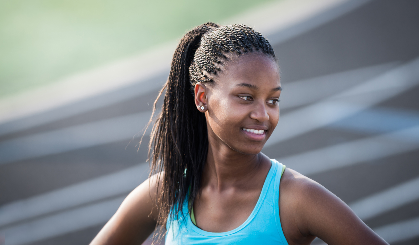 High School Athlete Smiling After Winning Race During Track Event